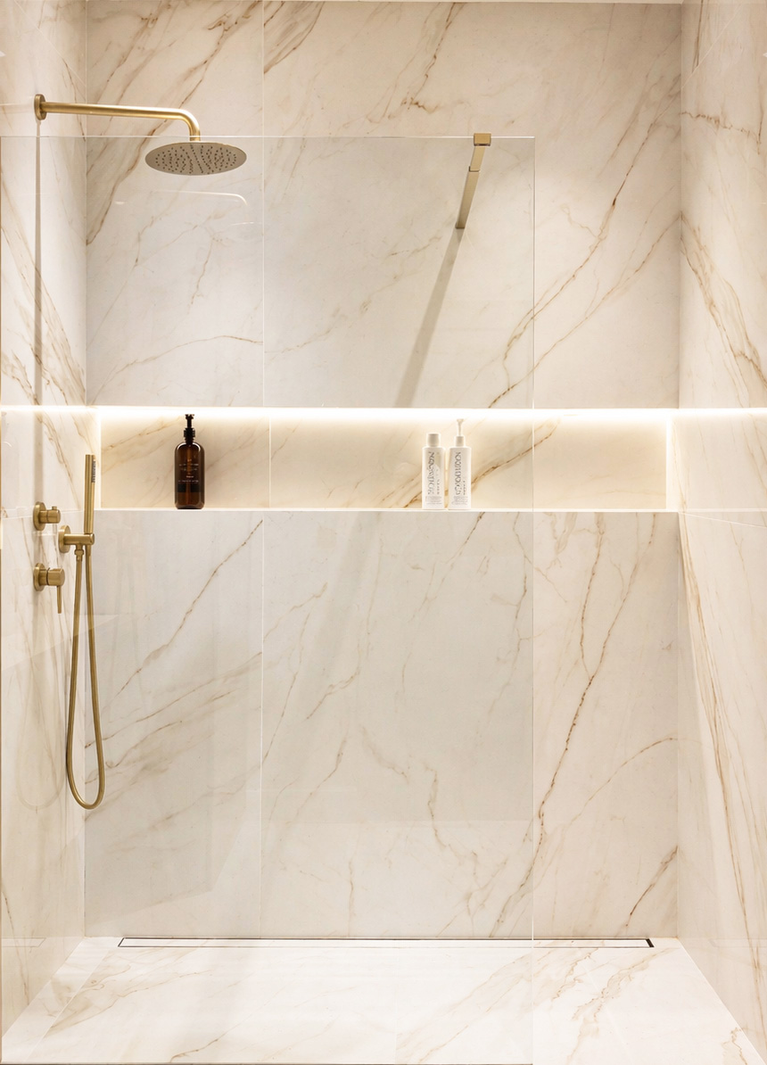 Guest bathroom with marble walls and brass rain shower